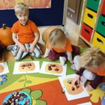 Przedszkolaki z oddziału Żuczki układają z kasztanów dynię