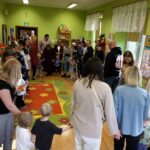 Przedszkolaki z rodzicami tańczą w kole