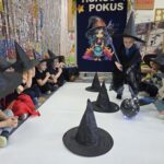 Chłopiec omija slalomem przszkody z miotłą i czarodziejską kulą