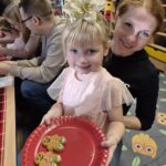 Dziewczynka z mamą dekoruje pierniczki