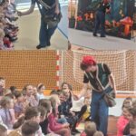 Krasnal Niezabudek szuka przez lupę zdrowego jedzenia