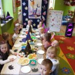 Zdjęcie grupowe dzieci z oddziału Żuczki przy stole z poczęstunkiem