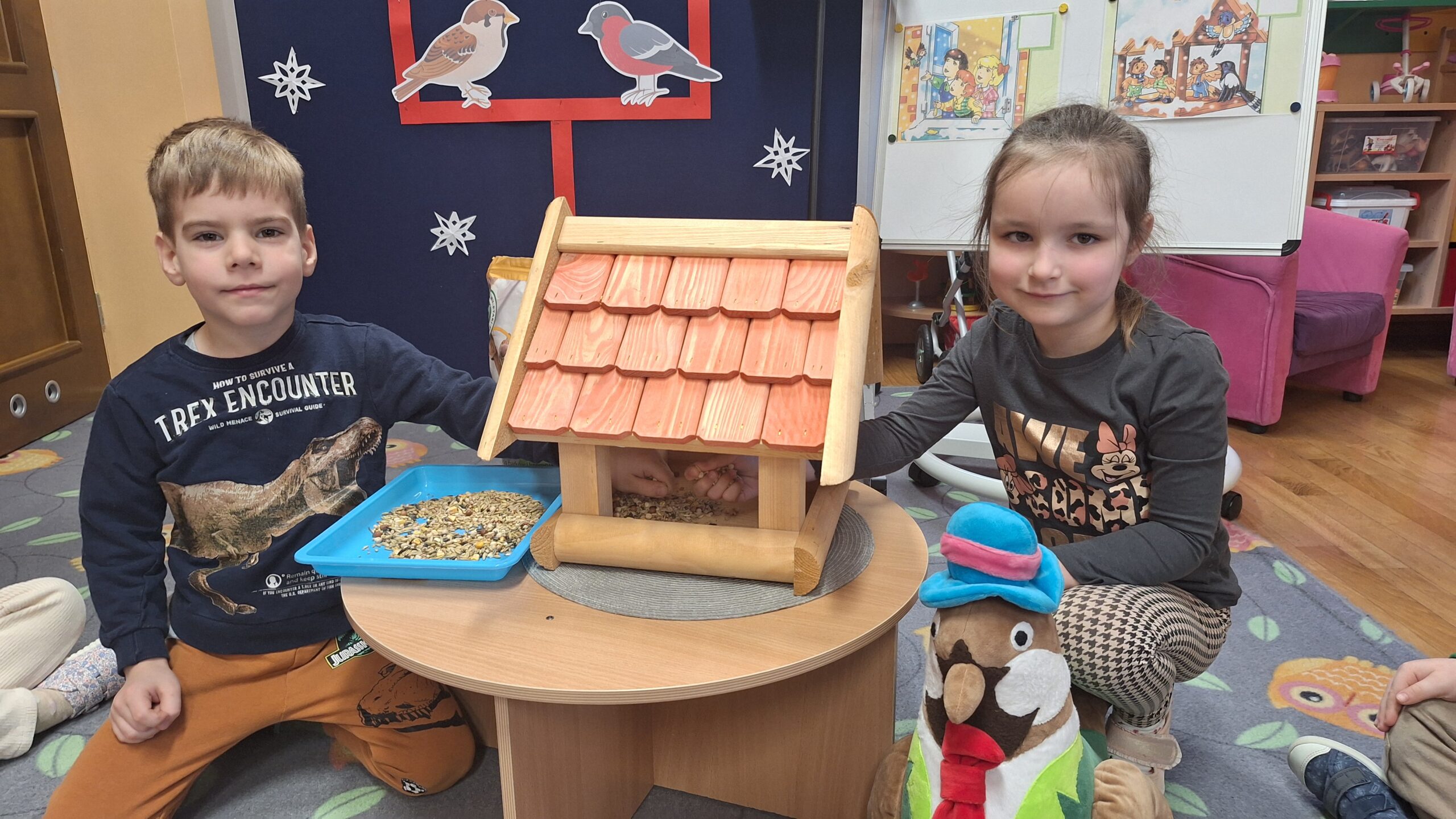 Dzieci wsypują karmę dla ptaków