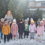 Dzieci z wychowawcą przy karmniku