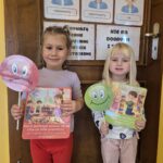 Dziewczynki trzymają ilustracje