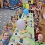 Dzieci przy stole z poczęstunkiem