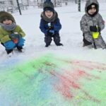 Dzieci-psikaja-kolorowymi-farbami-na-bialy-snieg