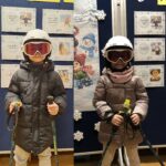 Dzieci ubrane w gogle, narciarze z kijkami