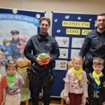 Dzieci wręczają policjantom kwiatki
