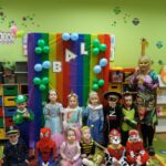 Dzieci z oddziału Żuczki w karnawałowych strojach przy ściance