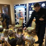 Policjant wręcza dzieciom odblaski