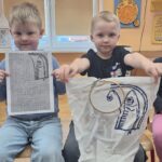 Chłopcy pokazują pracę wykonaną na szydełku