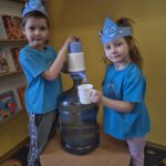 Chłopiec nalewa wodę do kubka