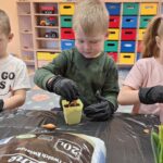 DZieci sadzą cebulę dymkę