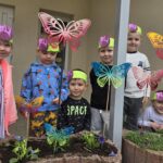 Dzieci-pozuja-przy-klabach-z-wiosennymi-kwiatami