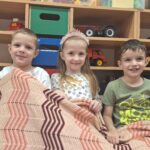 Dzieci trzymają koc