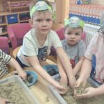 Dzieci wyciągają śmieci z piasku