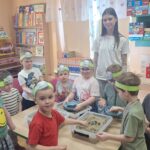 Przedszkolaki przy stoliku z piaskiem