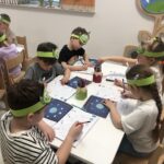 Dzieci rozwiązują zadania w kartach pracy