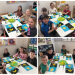 Dzieci wykonują pracę plastyczną przy stolikach