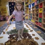 Dziewczynka chodzi po kasztanach