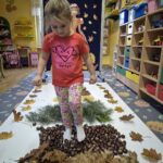 Dziewczynka przechodzi przez jesienną ścieżkę sensoryczną