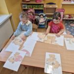 Dziewczynki składają obrazek z części