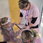 Dzieci wręczają kwiaty i podziękowanie