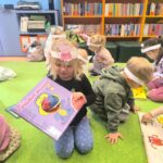 Dziewczynka bawi się maskotką z książki
