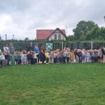 Dzieci pokazują znak miejsce zbiórki