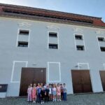 Dzieci przed budynkiem zabytkowego spichlerza