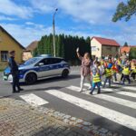 Dzieci z oddziału Rzeczyca przechodzą przez pasy pod czujnym okiem Policjantów