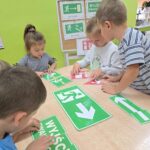 Dzieci z oddziału Tulipanki układają puzzle ze znaków ewakuacyjnych