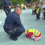 Pan Policjant tłumaczy jak wygląda pozycja na żółwia w razie ataku groźnego psa