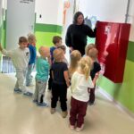 Pani pokazuje szafkę przeciwpożarową
