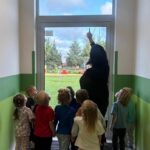 Pani pokazuje znak drogi ewakuacyjnej