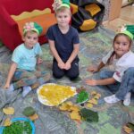 dzieci układają dary jesieni z produktów sensorycznych