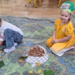 dzieci układają dary jesieni z produktów sensorycznych