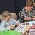 dzieci wraz z seniorami wykonują jesienne ludziki