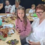 dzieci wraz z seniorami wykonują jesienne ludziki