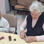 dzieci wraz z seniorami wykonują jesienne ludziki