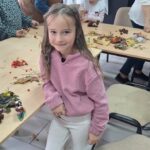 dzieci wraz z seniorami wykonują jesienne ludziki