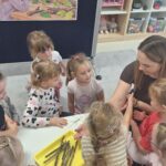 Nauczycielka z dziećmi oglądają patyczaki